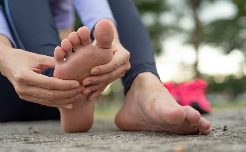 Kvinde masserer sin fod
