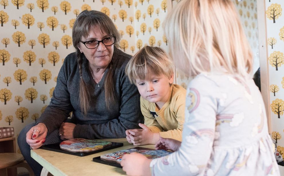 Pædagogisk assistent Tina Stub lægger puslespil med to børn