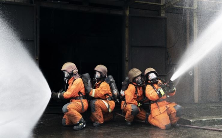 Fire kvindelige brandfolk slukker ild