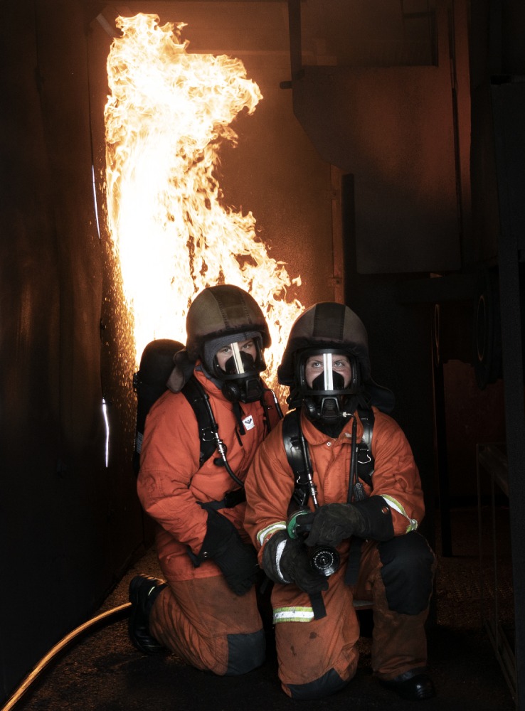 To kvindelige brandfolk foran ild