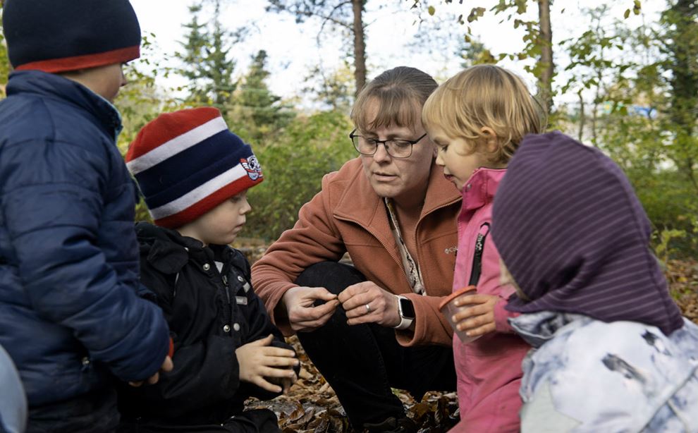 Pædagogisk assistent taler om dyr med børn i skoven